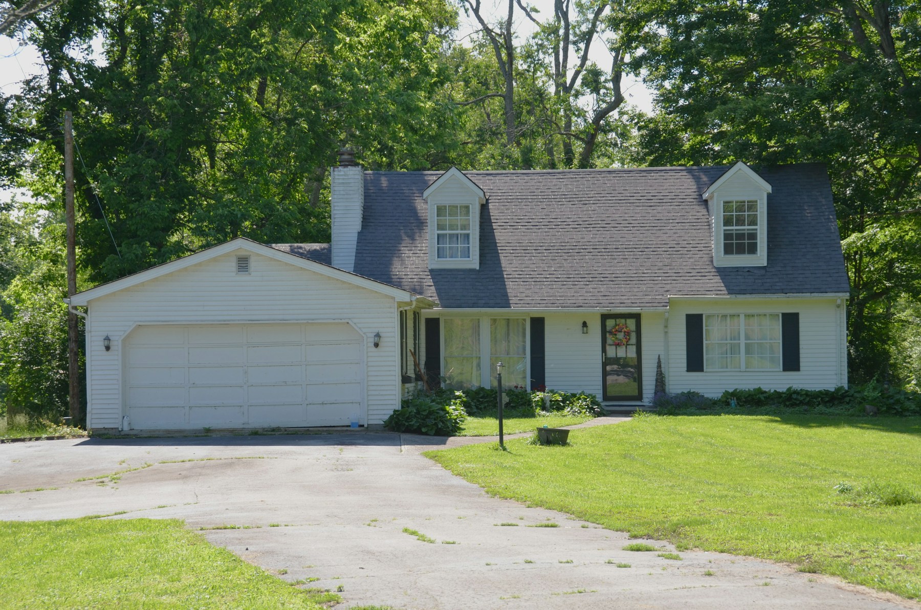 White house with a garage and green lawn