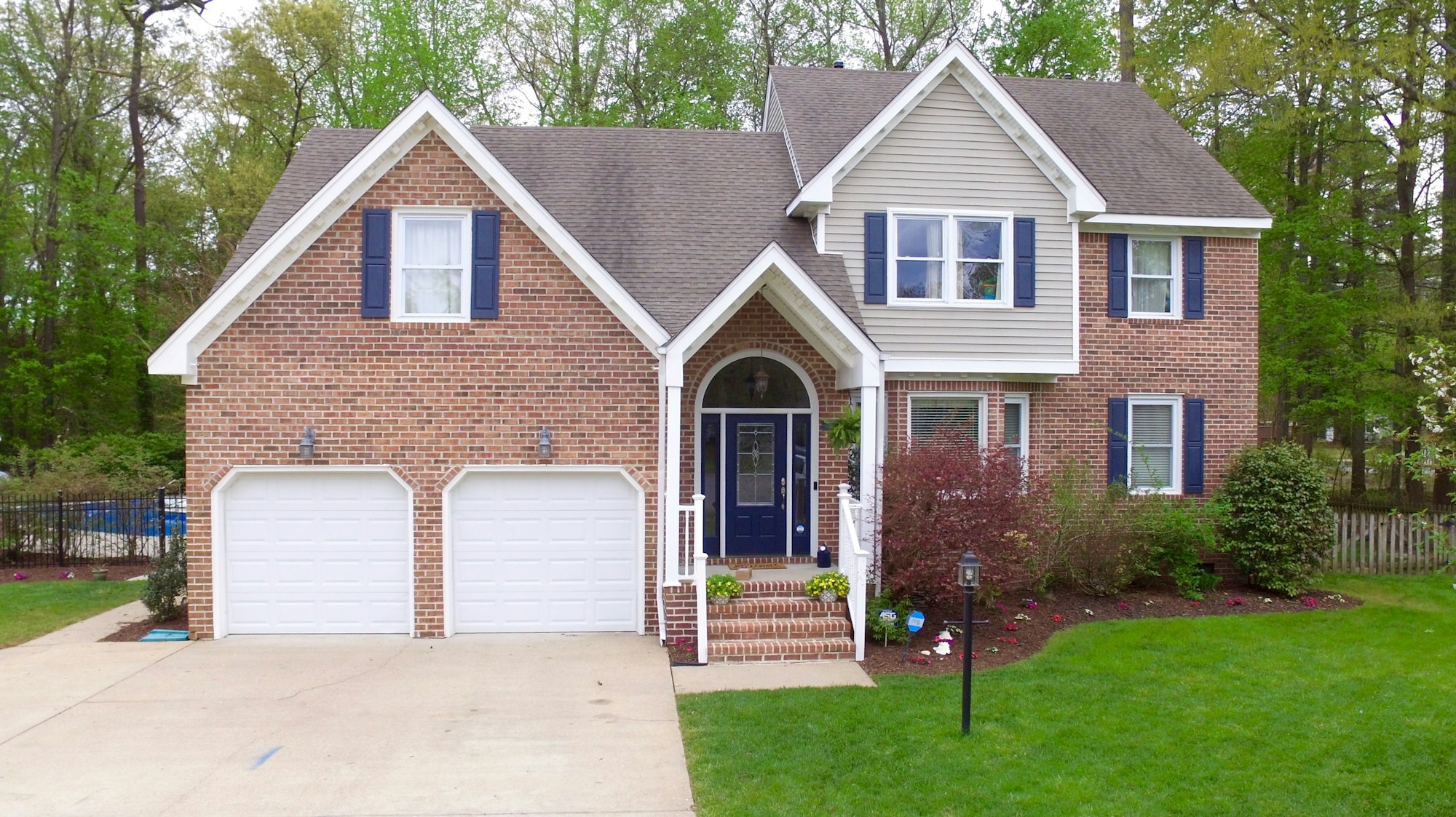 Brick home with a broad driveway and green lawn